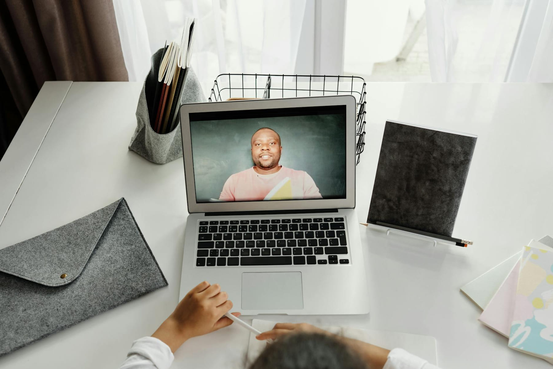 A student participates in a virtual class with a teacher on a laptop screen. on The Course Compass