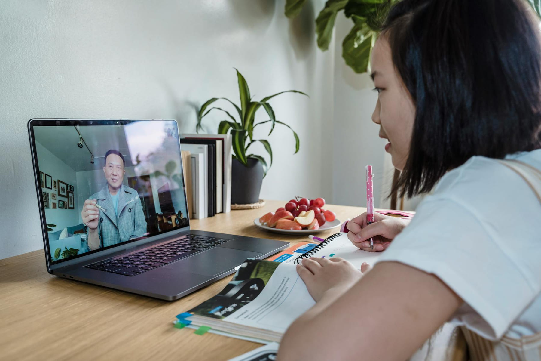 Young girl engaged in online learning via video call, studying with laptop and notes. on The Course Compass