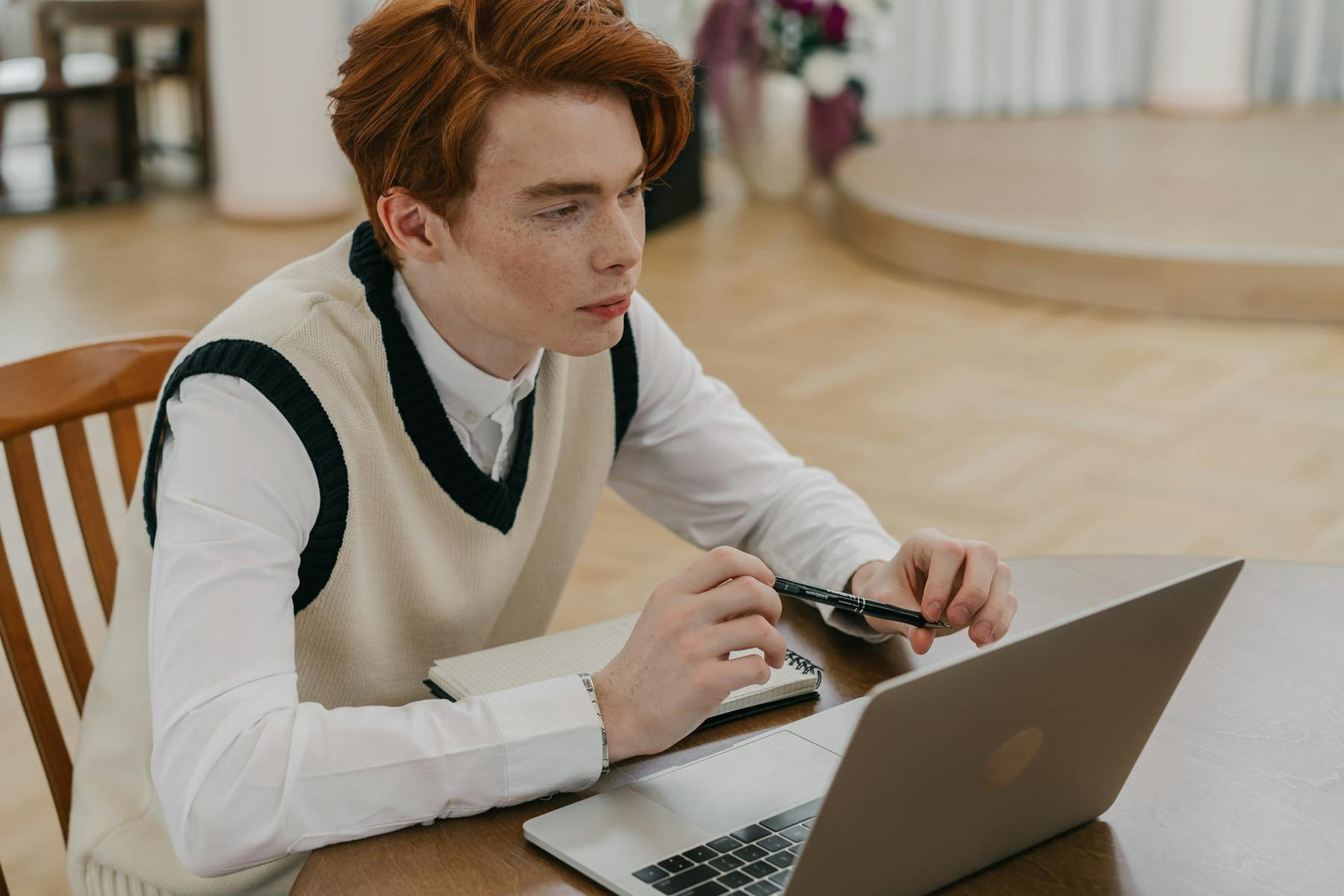 Focused young man engaged in online learning at home with a laptop and notebook. on The Course Compass