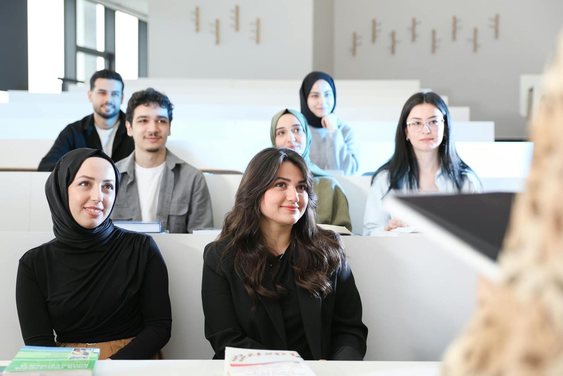Diverse group of students attentively listening in a university lecture hall. on The Course Compass