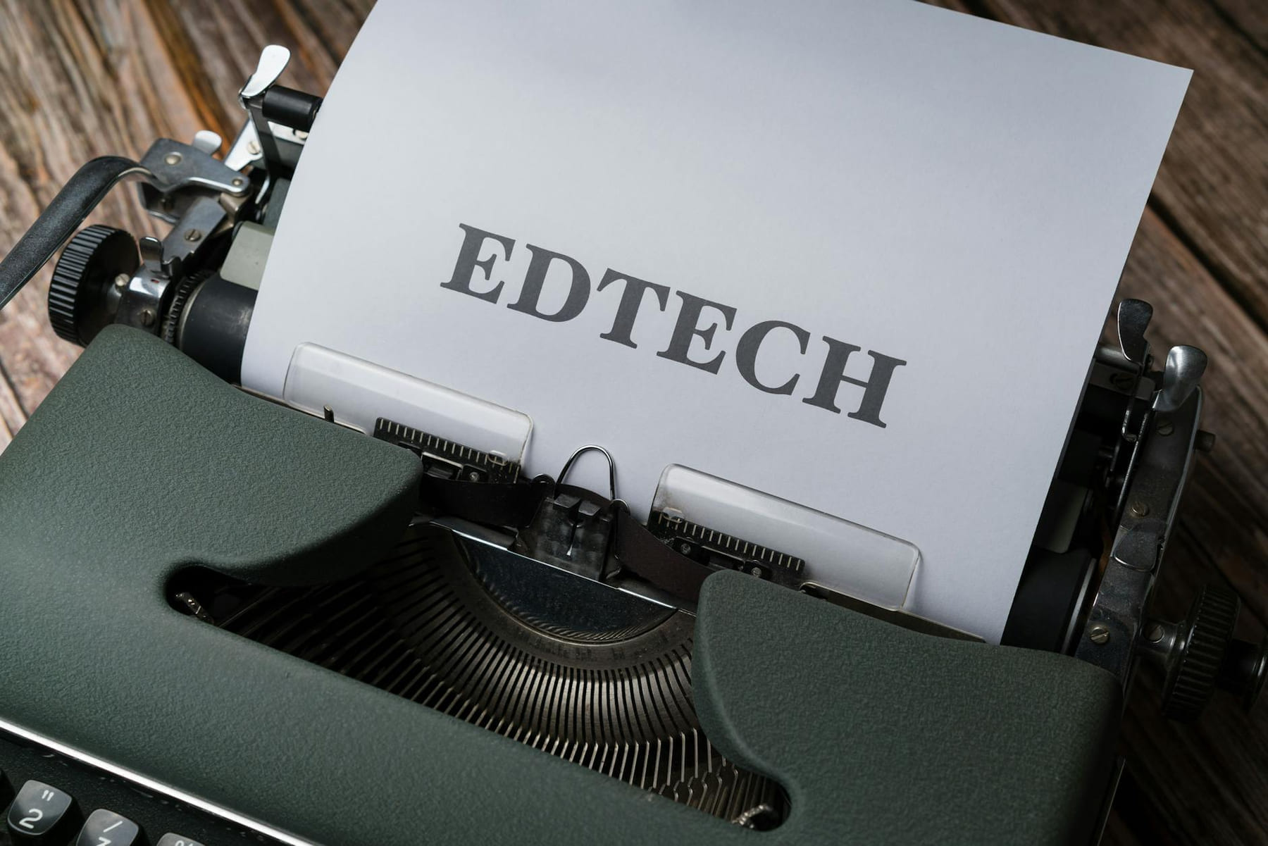 A classic typewriter with a sheet of paper displaying the word 'EDTECH.' on The Course Compass