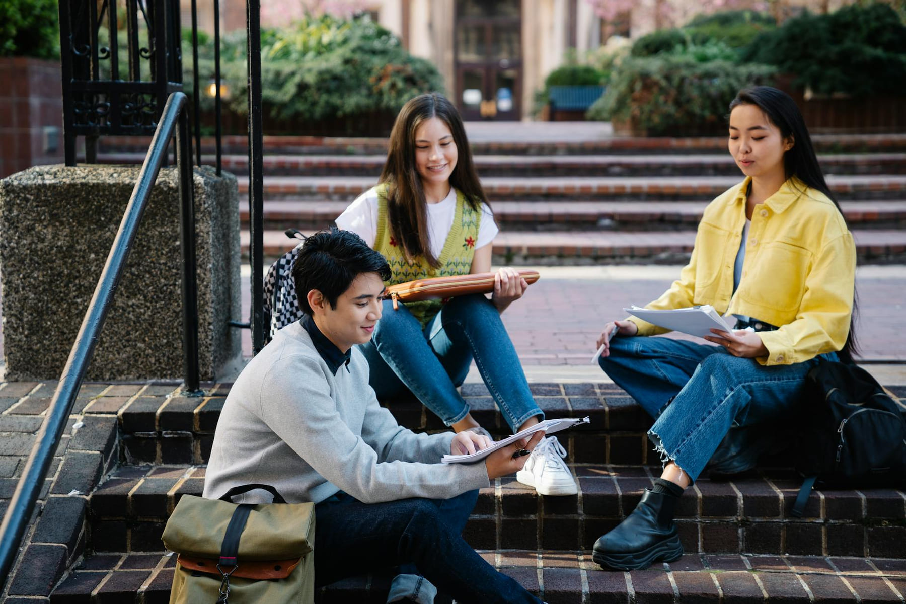 Group of students studying outdoors on college campus steps, enjoying sunny day. on The Course Compass