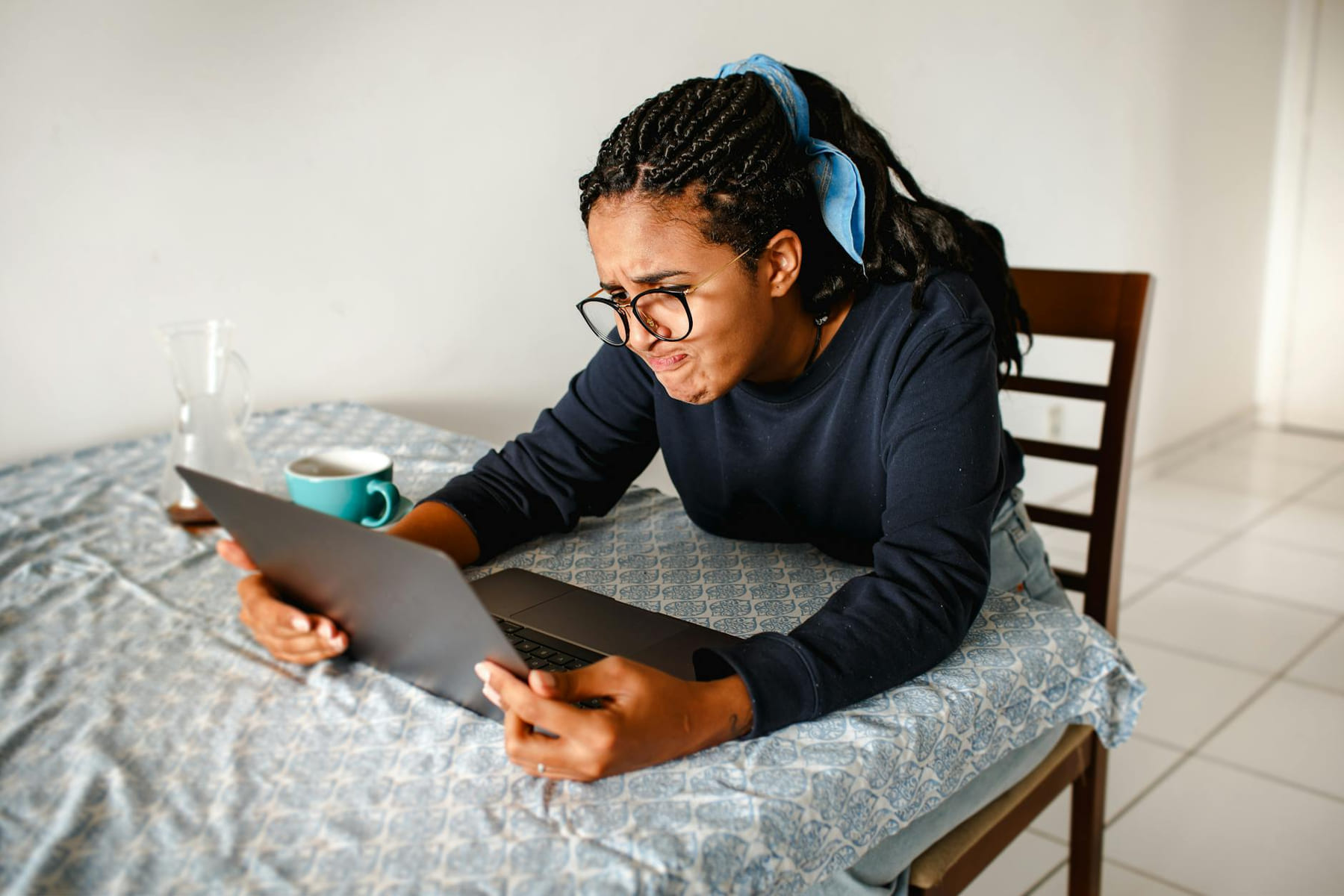 A young woman expressing frustration while using a laptop at home. on The Course Compass