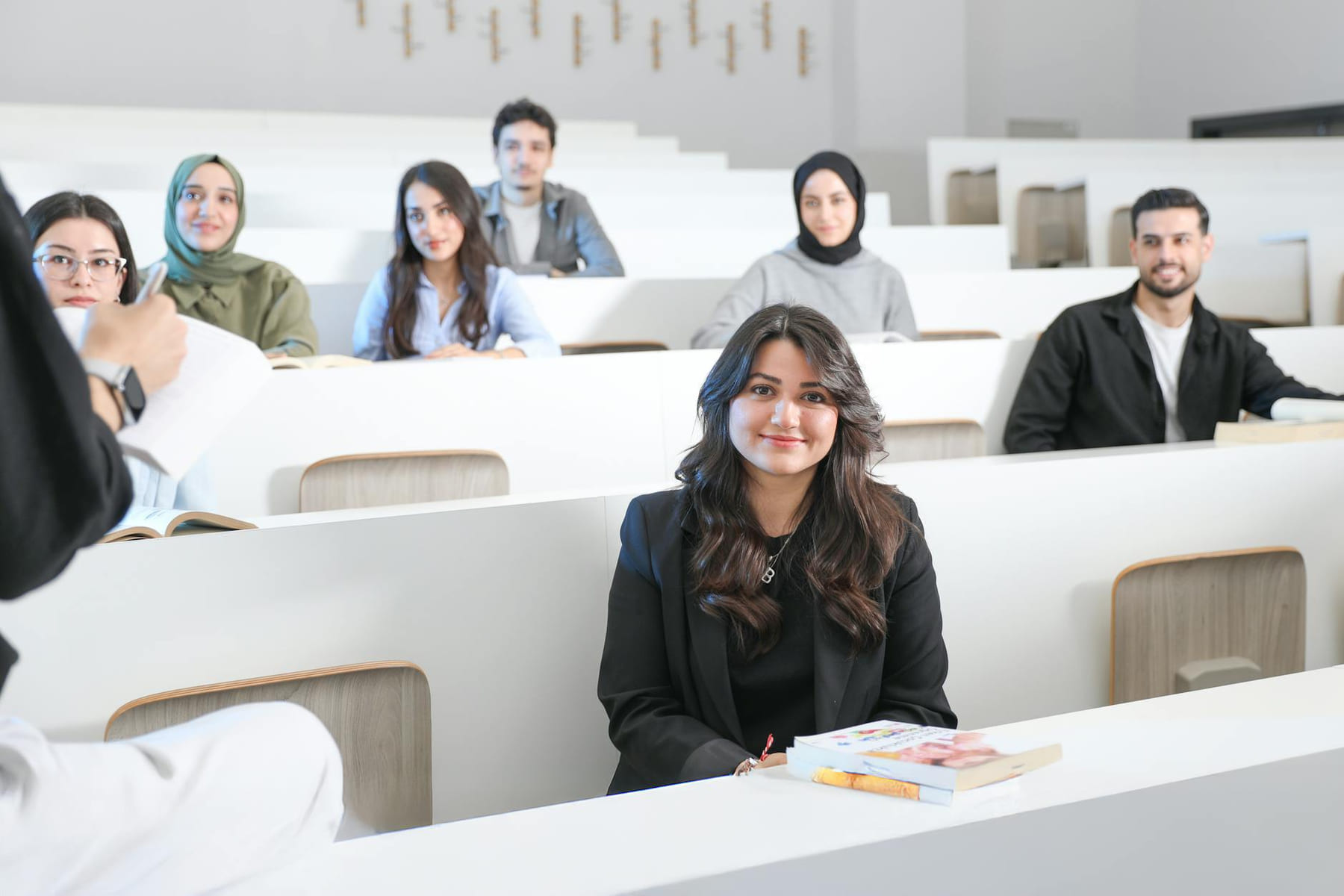 Students listening attentively in a bright university lecture hall. on The Course Compass
