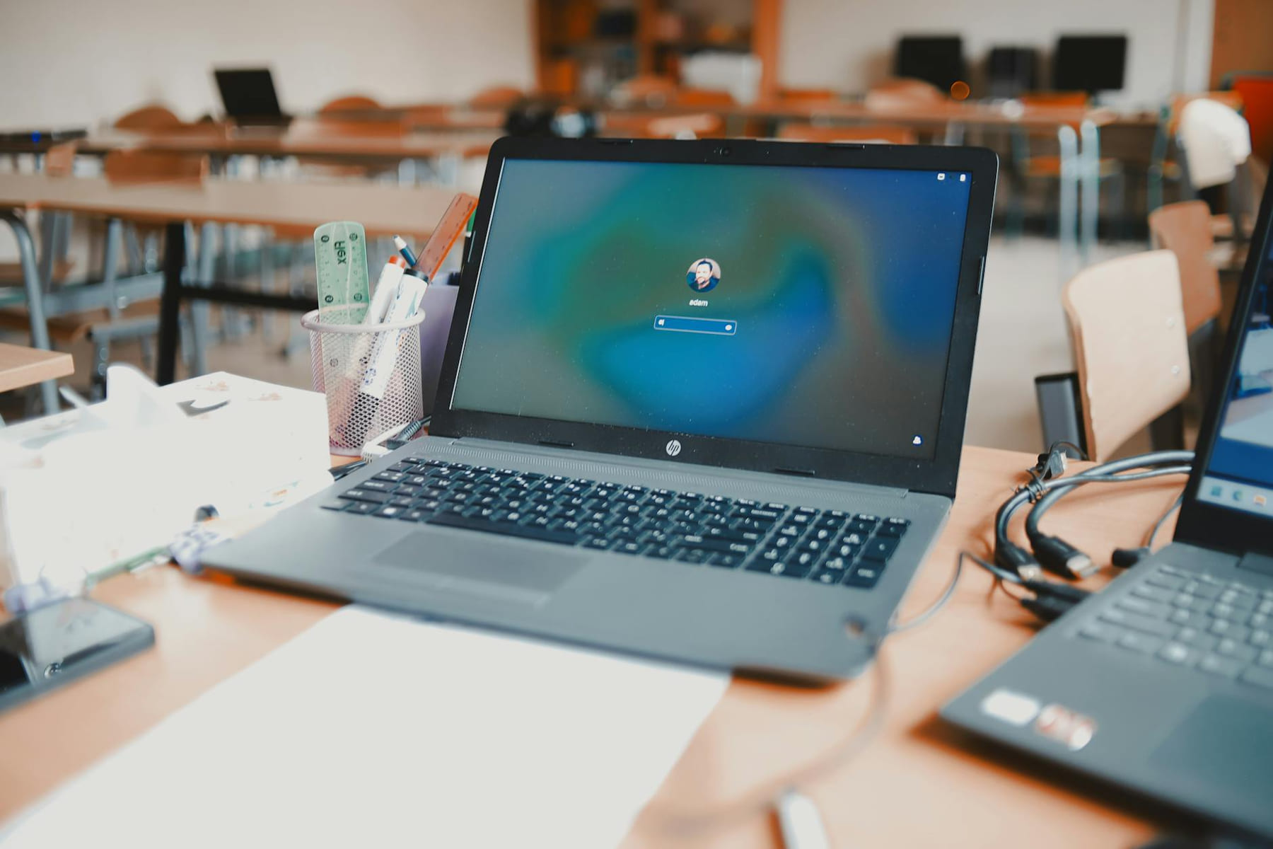 A close-up of a laptop on a desk in a classroom setting, ready for educational use. on The Course Compass