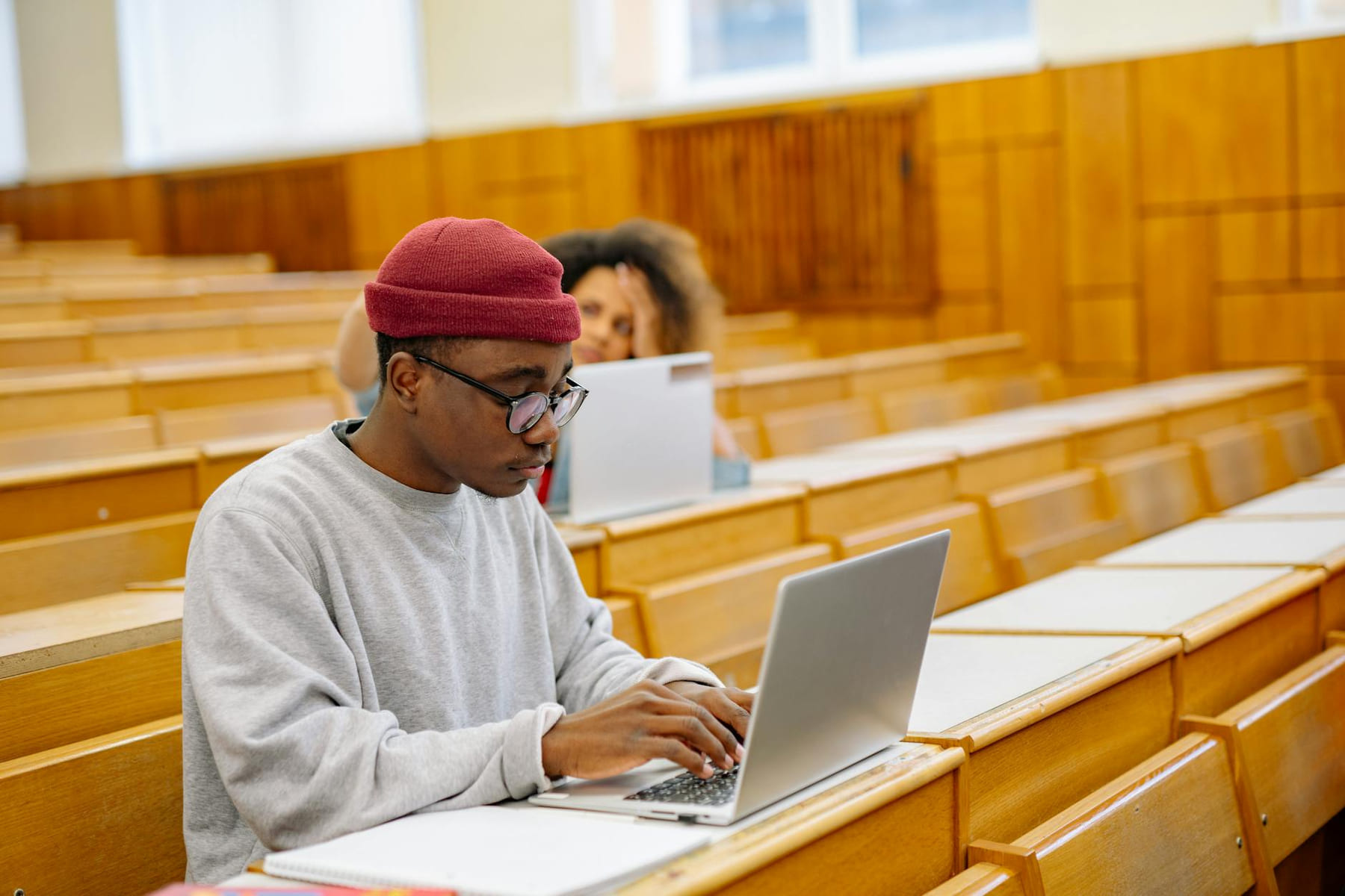 Students focus on laptops in a spacious university lecture hall, learning and working digitally. on The Course Compass
