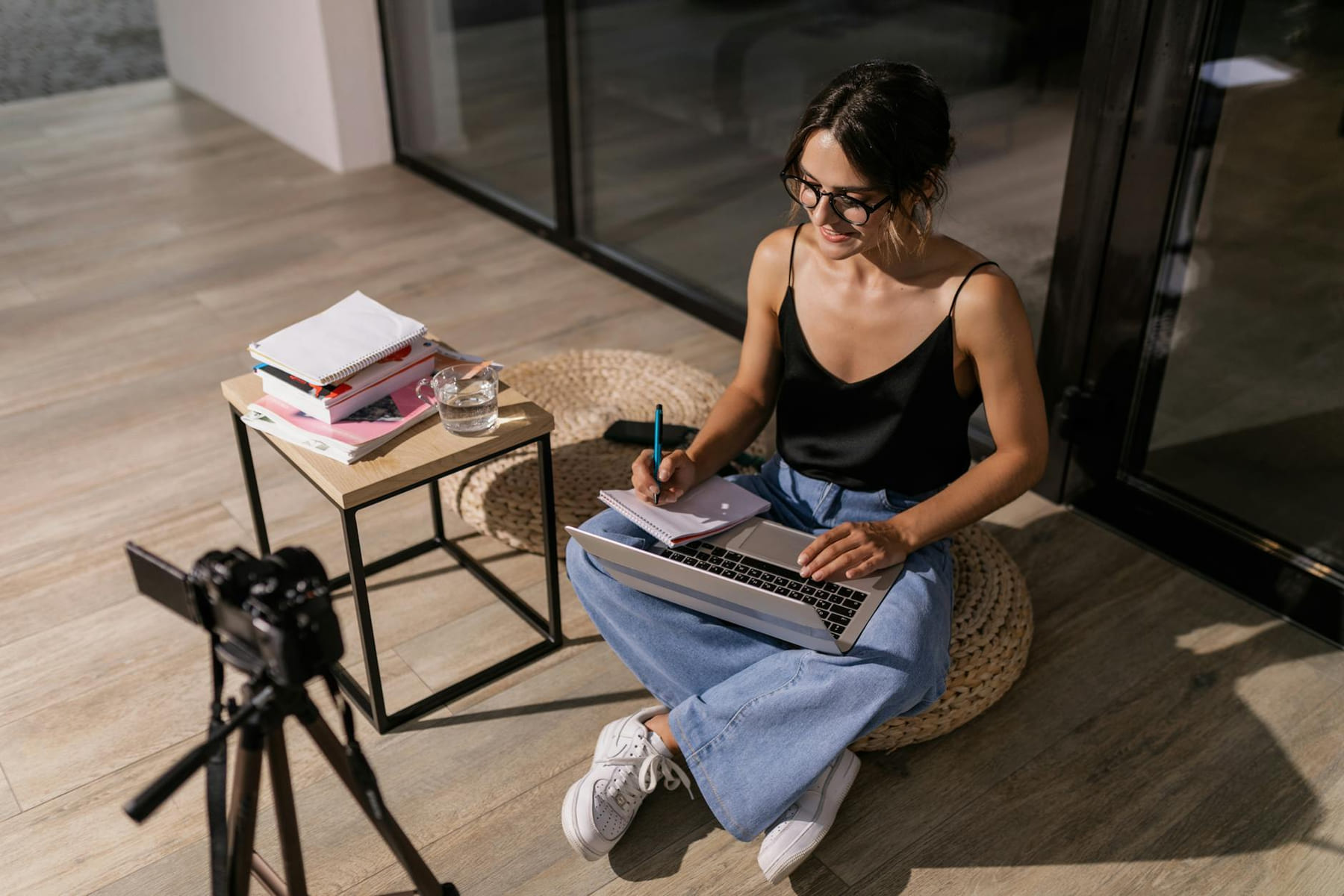 Young woman studying indoors with a laptop and camera setup, symbolizing remote learning. on The Course Compass
